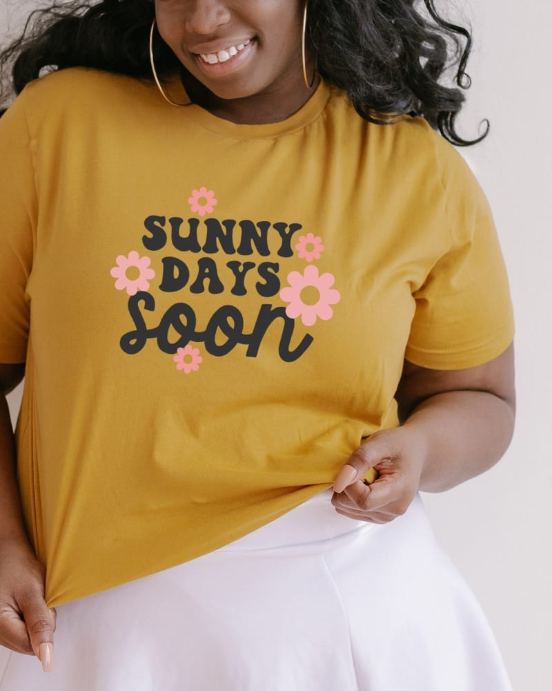 Front of a model wearing a size Large Sunny Days Soon Flowers in Mustard by Simply Sage Market. | dia_product_style_image_id:281779
